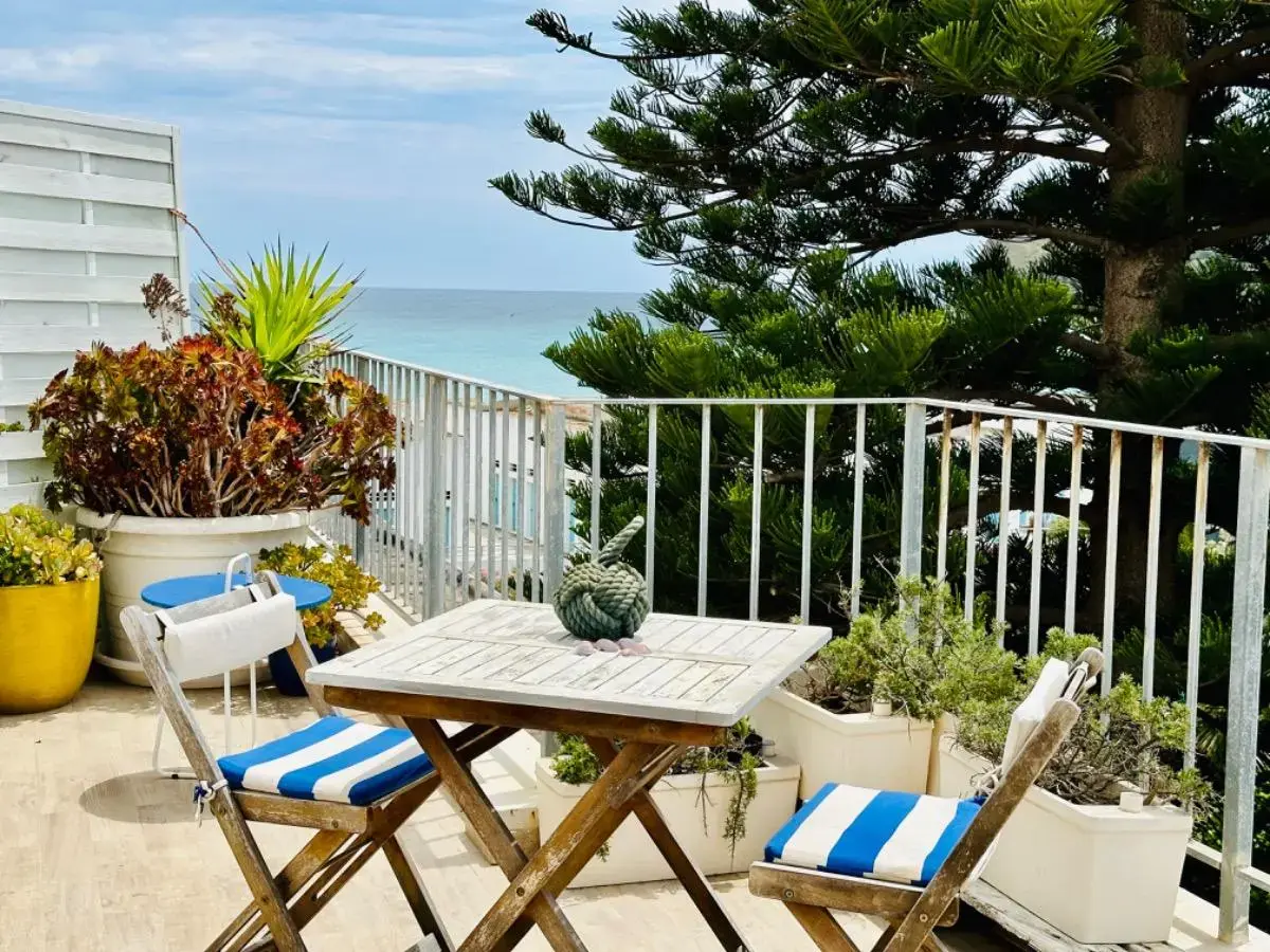Balcone con tavolino e sedie pieghevoli con vista sul mare tra i pini