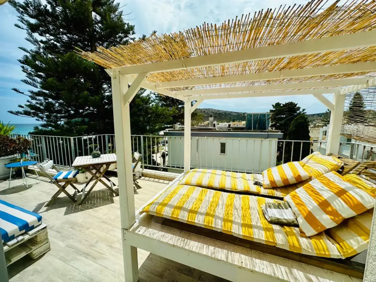 Terrazza con pergola di canne e lettino con cuscini gialli a righe